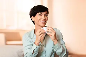 Middle Aged Prints: Middle aged brunette lady enjoying her morning coffee sitting indoor
