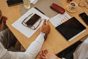 Coworkers Prints: Middle-aged male business person explaining something to his blonde female partner