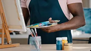Trouble Prints: Middle-aged mature senior 50s African artist painter painting drawing picture in art studio with acrylic oil draw