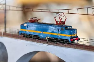 Plaything Prints: Miniature electric locomotive model crossing bridge, vintage toy train