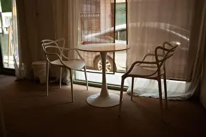 Bistro Prints: Minimal chairs and a small table arranged by a window inside a quiet cafe
