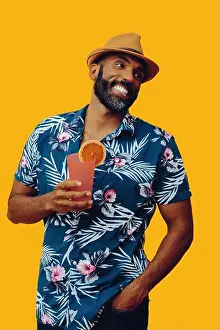 Looking Away Prints: Mixed-race bearded man wearing Hawaiian shirt and fedora hat holding orange juice