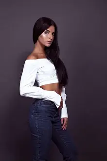 Make Up Prints: A model posing in a studio wearing jeans and a crop top. Stock Photo