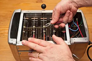 Toaster Prints: A MODEL RELEASED man mending a toaster in the Uk