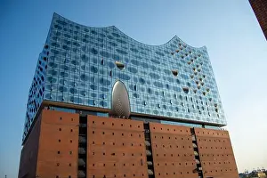 Innovative Design Prints: A modern architectural building with a unique wavy glass facade and brick base