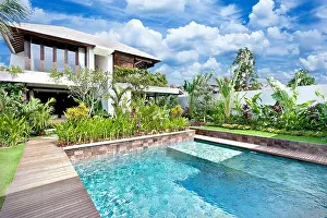 Poolside Prints: Modern blue water swimming pool in a luxury house with a fancy garden around it