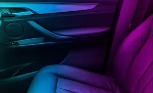 Upholstery Prints: Modern luxury car black perforated leather interior in pink blue tones
