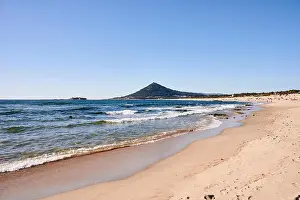 Sandy Prints: Moledo beach on a spring day, with waves on the sea and a mountain in the background
