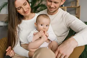 Mommy Prints: Mom, dad and six-month-old baby son in their arms spend time together in their cozy home