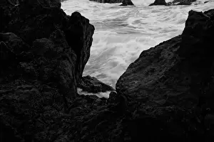 Monochrome glimpse of swirling ocean waters framed by dark volcanic rocks at Porto Moniz natural pools
