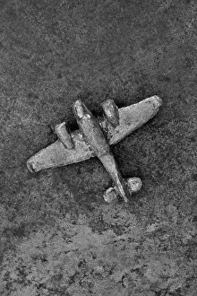 Propellers Prints: Monochrome image of vintage lead model airplane on tarnished metal