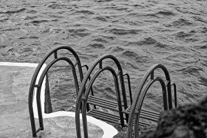 Natural Pools Prints: Monochrome of a ladder that leads into the churning ocean waters in Porto Moniz natural pools