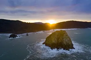Morning light illuminates rocky sea stacks just off the coast of Northern California in Klamath. The Pacific Coast Highway runs along this shoreline