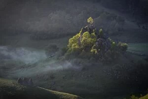 Images Dated 23rd May 2016: Morning sunshine with fog over a mountain landscape with a rock and trees in direct sunlight