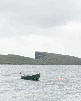 Morning view on lonely boat on cloudy Sorvagsvatn lake on cliffs of Vagar island, Faroe Islands, Denmark. Landscape photography