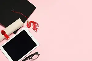 Degree Prints: Mortar board with diploma, eyeglasses and modern tablet computer on pink background