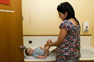Nappy Prints: mother changing nappies on a six month year old baby