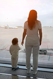 Boarding Prints: Mother and child watching airplane taking off from airport window