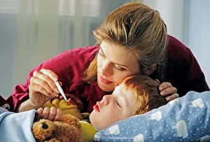Concern Prints: A mother comforts her sick child in bed