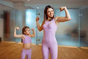 Gymnastic Prints: Mother and daughter shows the muscles in gym