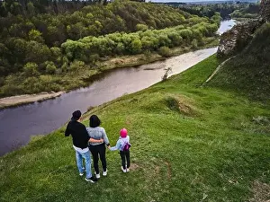 Mother, father daughter enjoys the view on the coast Sluch river hills, Gubkiv village Travel destinations in Ukraine