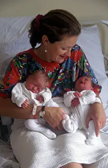 Offspring Prints: mother with newborn twins sitting up in hospital bed smiling