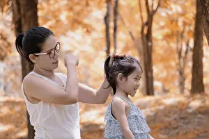 Hairdo Prints: Mother is styling daughters hair outdoors