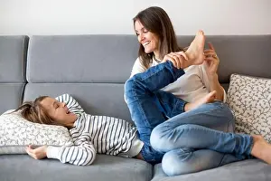 Tickle Prints: Mother, tickling her little boy, child giggling at home with mom in living room