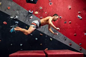 Climber Prints: Motion shot of male climber falling on mat from climber wall at an indoor climbing gym