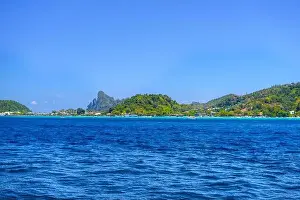 Krabi Prints: Motor ship in the bay of Ko Phi Phi Don Island with huge rocks and cliffs on a sunny day