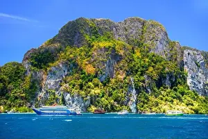 Krabi Prints: Motor ship in the bay of Ko Phi Phi Don Island with huge rocks and cliffs on a sunny day