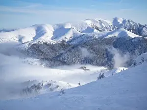 Winter Scenery Prints: Mountain chalet in winter landscape with low altitude clouds in bright sunny day