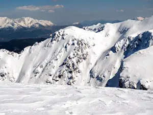 Ski Resort Prints: The top of the mountain Helmos in Kalavrita ski resort with snow and clouds in a sunny day
