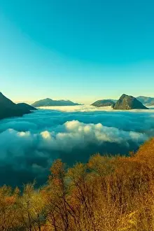 Lugano Prints: Mountain Peak San Salvatore Above Cloudscape with a Autumn Tree and Sunlight with Clear Sky in Lugano