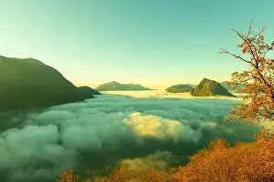 Lugano Prints: Mountain Peak San Salvatore Above Cloudscape with a Autumn Tree and Sunlight with Clear Sky in Lugano