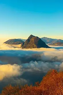 Lugano Prints: Mountain Peak San Salvatore Above Cloudscape with a Autumn Tree and Sunlight with Clear Sky in Lugano