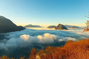 Lugano Prints: Mountain Peak San Salvatore Above Cloudscape with a Autumn Tree and Sunlight with Clear Sky in Lugano
