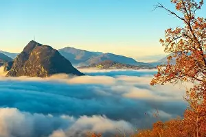 Lugano Prints: Mountain Peak San Salvatore Above Cloudscape with a Autumn Tree and Sunlight with Clear Sky in Lugano