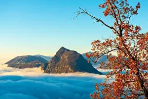 Lugano Prints: Mountain Peak San Salvatore Above Cloudscape with a Autumn Tree and Sunlight with Clear Sky in Lugano