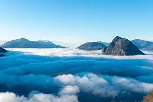 Mountain Peak San Salvatore Above Cloudscape with a Autumn Tree and Sunlight with Clear Sky in Lugano