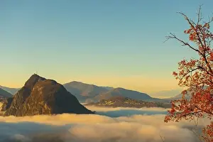 Mountain Peak San Salvatore Above Cloudscape with a Autumn Tree and Sunlight with Clear Sky in Lugano