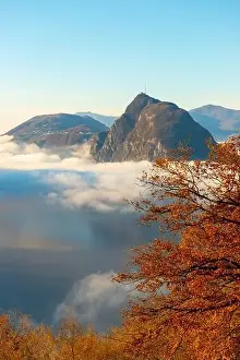 Lugano Prints: Mountain Peak San Salvatore Above Cloudscape with a Autumn Tree and Sunlight with Clear Sky in Lugano