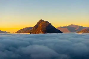 Lugano Prints: Mountain Peak San Salvatore Above Cloudscape with Sunlight and Clear Sky in Lugano