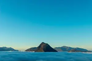 Lugano Prints: Mountain Peak San Salvatore Above Cloudscape with Sunlight and Clear Sky in Lugano