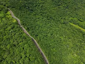 Mountain road on green hill jungle background on sunny day aerial drone view