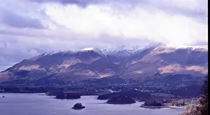 Lake District Prints: Mountains snow clouds and winter sunlight over Lake Derwentwater in the Lake District in the North West of England