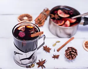 Punch Prints: mulled wine in a glass with an iron cup holder on a white wooden background, top view