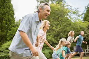 On The Move Prints: Multi-generation family holding hands and running