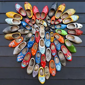 Multi Color Prints: multicolored vintage dutch wooden shoes in shape of heart on black wood panel background