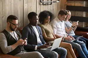 Texting Prints: Multiracial black and white people sitting on couch using device